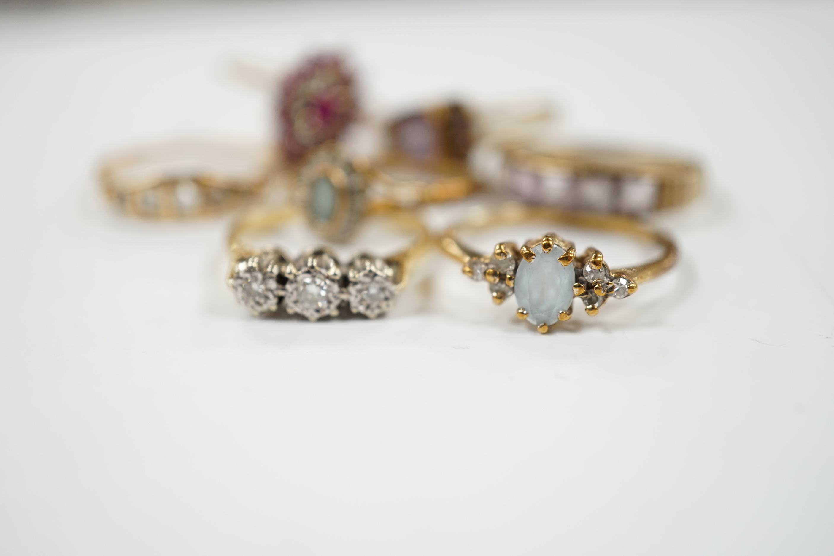 Seven assorted mainly modern 9ct gold and gem set dress rings, including three stone diamond and five stone diamond, gross weight 15.7 grams.
